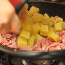 Agregar las papas ya escurridas, revolver y rectificar la sazón, seguir cocinando durante 3 minutos más.