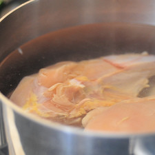 Poner a cocer la pechuga de pollo con piel en una olla honda con agua y sal durante 40 minutos.