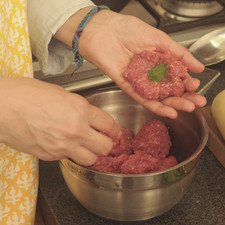 Mezclar la carne molida en un tazón con el huevo y un poco de sal. Con las manos formar bolitas con la carne, aproximadamente del tamaño de una pelota de ping-pong o de golf. Poner una hojita de hierbabuena en el centro de cada albóndiga.