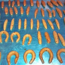 Forma bolitas (besitos), palitos (dedos de nuez) y cuernitos. También puedes hacer las formas que desees. Coloca las galletas en una charola y hornea hasta que estén listas. No dejes que se quemen.