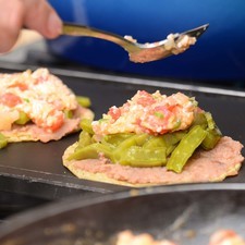 Colocar la otra tortilla encima para cubrirla. Calentar un minuto más de cada lado sobre el comal.
