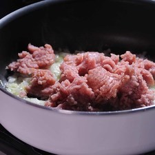 Agregar el ajo y la carne molida moviendo constantemente hasta que el color rojo desaparezca y los jugos se evaporen durante 15 minutos.