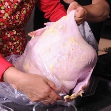 Para hornear el pavo, acomodar el pavo en la bolsa para hornearlo y colocarlo sobre la charola honda.