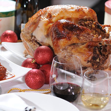 Sacar el pavo ya dorado del horno, sacarle el relleno con una cuchara, rebanar la carne con un cuchillo eléctrico. Servir las rebanadas de pavo, bañadas con la salsa y acompañadas del relleno.