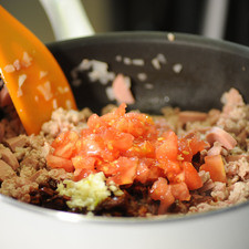 Agregar los tomates picados, el diente de ajo picado y la pulpa de los tomates. Sazonar con sal y pimienta. Dejar cocer 5 minutos más moviendo con frecuencia.