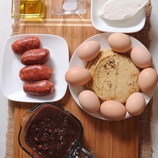 1/2 taza de crema de leche de vaca 2 tazas de frijoles negros cocidos 1/4 cucharita de sal 2 cucharadas de aceite de oliva 200 gramos de queso fresco 200 gramos de chorizo 8 piezas de huevo 12 piezas de tortilla de maíz