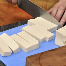 Cortar la cebolla y los pimientos en tiras tipo juliana. Picar finamente le diente de ajo. Retirar el agua al tofu y escurrir lo más que se pueda, ayudarse de papel absorbente. Cortar en tiras largas de 1 cm de ancho por 2 cm de largo.