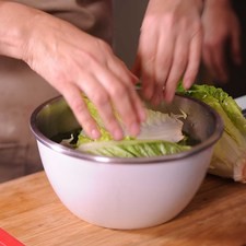 Para preparar la ensalada, desinfectar la lechuga en un tazón con agua y unas gotas de desinfectante. Escurrir y cortar en trozos.