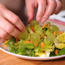 Colocar en una ensaladera la lechuga, zanahoria, apio, uvas y la nuez picada.