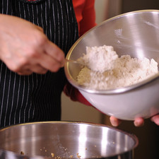 Agregar los ingredientes secos a la mantequilla. Revolver todos los ingredientes con la ayuda de una cuchara. Agregar dos cucharadas más de harina y amasar bien con las manos hasta integrar.