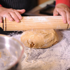 Colocar papel encerado sobre la charola y untar un poco de aceite vegetal uniformemente para que no se peguen las galletas. Extender la masa con la ayuda del rodillo sobre una mesa enharinada.