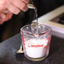 Para preparar el glaseado, mezclar en un tazón el azúcar glass, con unas gotas de limón y la cucharita de agua utilizando una cuchara hasta obtener una mezcla suave.