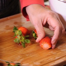 Cortar el pedúnculo a las fresas ya desinfectadas y cortar en dos.
