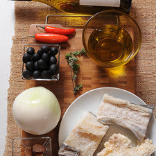 1/4 cucharita de pimienta negra molida 1/4 taza de aceitunas negras 4 dientes de ajo 2 ramas de orégano fresco 2 piezas de chile serrano rojo Help 1/4 taza de aceite de oliva extra virgen 1 pieza de cebolla blanca 500 gramos de lomo de bacalao sin espinas Ingredientes para acompañar: 1 pieza de baguette