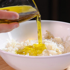 Poner el bacalao desmenuzado en un tazón, añadir el aceite de oliva.