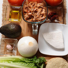 sal al gusto al gusto 3 piezas de jitomate bola 100 gramos de queso fresco 1 pieza de aguacate 1 pieza de lechuga 6 piezas de tostadas de maíz 2 cucharadas de aceite de oliva 1 diente de ajo 2 piezas de chile chipotle adobado 1 pieza de cebolla blanca 2 tazas de pierna de cerdo