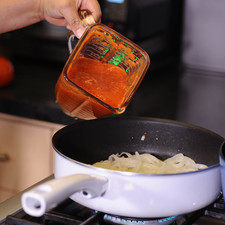 Sofreír en un sartén la cebolla cortada en rodajas con las dos cucharadas de aceite durante unos minutos, hasta que se vea transparente. Agregar el jitomate molido, sazonar con sal y dejar hervir durante 5 minutos.