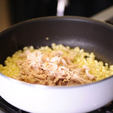 Desgranar el elote. Picar la cebolla finamente. Poner a calentar el sartén. Cuando el punto rojo indique que está caliente, agregar un poco de aceite de oliva y el elote desgranado, cocinar durante 3 minutos.