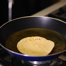 Calentar el sartén, cuando el punto rojo indique que está caliente, añadir un poquito de aceite y pasar las tortillas.