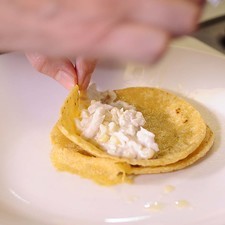 Colocar en un plato una tortilla, agregar el relleno y enrollarlas.