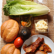 4 rebanadas de pierna de cerdo 1/2 cucharita de sal 4 cucharadas de aceite de oliva chiles en vinagre al gusto 1 pieza de aguacate 1 pieza de lechuga orejona 1 pieza de jitomate guaje 1 pieza de cebolla blanca 1 taza de frijoles refritos 1/4 taza de mayonesa 2 piezas de pan telera