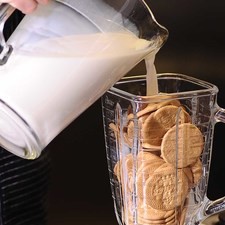 Moler las galletas con 3 tazas de leche o la cantidad que sea necesaria para obtener una mezcla homogénea. Reservar