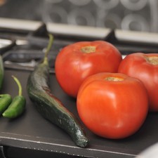 Tostar en le comal los chiles, los jitomates y la cebolla en rebanada a lumbre media, dándoles vuelta de vez en cuando para que adquieran una piel tostada.