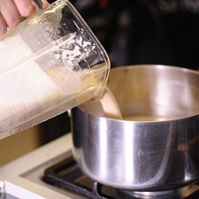Hervir el agua en una olla grande con la canela y el piloncillo a fuego alto hasta que se haya disuelto el piloncillo. Agregar el resto de la leche y poco antes que empiece a hervir incorporar las galletas molidas moviendo constantemente a fuego bajo hasta que hierva.