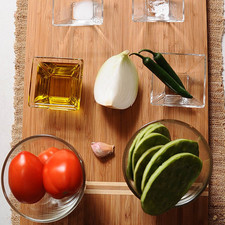 1/4 pieza de cebolla blanca 1 pizca de bicarbonato de sodio 1/4 taza de aceite de oliva 1/2 cucharita de sal 2 piezas de chile serrano 1 diente de ajo 3 piezas de jitomate guaje 8 piezas de penca de nopal