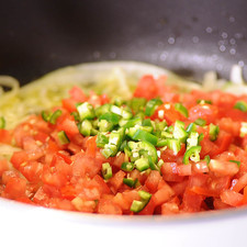Añadir los jitomates, el chile y continuar cociendo moviendo frecuentemente hasta que los tomates estén cocidos.