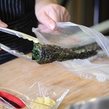 Picar las calabacitas, jitomates y la cebolla en cuadros pequeños a tamaño bocado. Desgranar los elotes frescos y reservar. Poner a asar en la hornilla los chiles poblanos dando vueltas con una pinza hasta que estén completamente asados pero no quemados. Colocar en una bolsa de plástico, añadir un poco de sal y dejar reposar durante 5 minutos para que se suden.