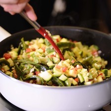 Añadir las calabacitas, el tomate y los chiles en rajas, continuar cociendo durante 2 minutos, moviendo con frecuencia.