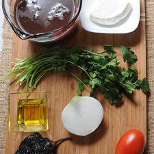 3 tazas de frijoles negros cocidos 10 ramas de cilantro sal al gusto 3 cucharadas de aceite de oliva 100 gramos de queso panela 1 pieza de chile ancho 1 pieza de jitomate guaje 1 pieza de diente de ajo 1/2 pieza de cebolla blanca
