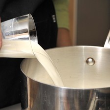 Poner al fuego la leche con la sal.