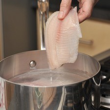 Lavar bien el pescado y cocinar en agua con sal, cuando esté cocido, pasar por un colador y sacar las espinas, desmenuzar.