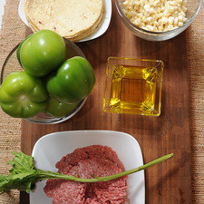 8 piezas de tortilla de maíz 1/4 pieza de cebolla blanca 6 piezas de tomate verde (tomatillo) pimienta negra molida al gusto 250 gramos de carne molida de res sal al gusto 1/4 taza de aceite de oliva 1 rama de epazote 1 taza de granos de elote