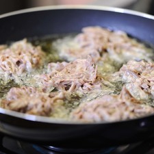 Calentar el sartén sobre la estufa. Agregar la taza de aceite de canola y dejar calentar. Sofreír las tortitas, volteando para que se cuezan parejo. Retirar y poner sobre un papel para retirar el exceso de aceite. Añadir las tortitas a la salsa y dejar hervir 2 minutos más.