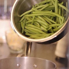 Para preparar las tortitas, limpiar los ejotes, retirándoles las hebras. Hervir los ejotes en una olla onda con agua y una pizca de bicarbonato, hasta que estén cocidos.