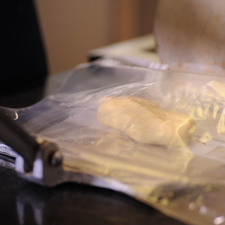 Tomar un puño de masa y formar un rollito, colocar en la máquina tortilladora entre dos trozos de plástico, presionar para formar una tortilla ovalada de 1 centímetro de espesor. S 8887 1475619419