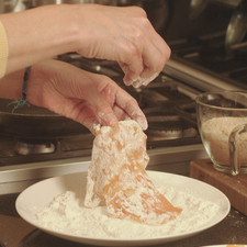 Empanizar las pechugas con la harina y sacudirlas para removerles el exceso.