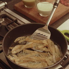 Calentar el aceite de oliva en una sartén abierta. Freír las tortillas cortadas en tiras, volteándolas con frecuencia utilizando una pala con cuidado de que no se rompan. A media cocción sazonar con un poco de sal y continuar hasta que estén doradas crujientes pero no quemadas.