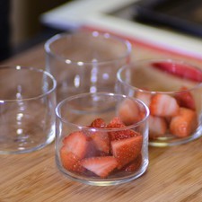 Retirar del fuego, vaciar en un tazón y colocarlo dentro de otro con agua helada para enfriar la mezcla. Guardar en el refrigerador esta crema inglesa hasta la hora de servir el postre. Para decorar las copas, poner a remojar las fresas en agua con unas gotas de desinfectante durante 5 minutos. Escurrir, retirar el pedúnculo y rebanar las fresas a lo largo. Colocar las fresas de manera decorativa dentro de las copas.