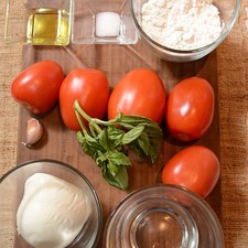 Ingredientes para para la pizza 1/2 taza de agua 1/4 cucharita de sal 1 cucharada de aceite de oliva 1 taza de harina de trigo Ingredientes para para el relleno 2 ramas de albaca Nuevo 200 gramos de queso mozzarella 1 diente de ajo 5 piezas de jitomate guaje