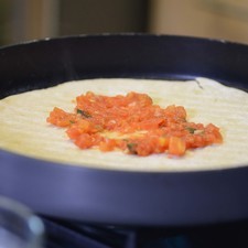 Poner la masa sobre el sartén grill de Perdura. Colocar sobre la estufa y cocer cinco minutos de un lado y voltear con la ayuda de una pala y cocer 5 minutos más. Añadir la salsa sobre toda la pizza.