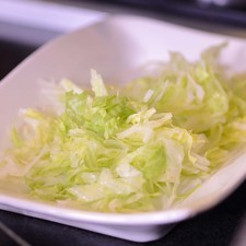 Mezclar en un tazón la crema con pimienta, sal y reservar. Colocar en un tazón la lechuga picada.