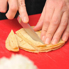 Picar finamente la cebolla. Cortar los chiles jalapeños en rajas, retirando las semillas y las venas. Cortar las tortillas en rajas y luego las rajas a la mitad.