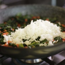 Desinfectar las espinacas en un tazón con agua y unas gotas de desinfectante, escurrir. Picar la espinaca y el pimiento morrón rojo finamente.Cocer el arroz en una olla honda con suficiente agua y la cucharita de sal, dejar cocer durante 15 minutos o hasta que esté al dente. Escurrir y rociar un chorrito de aceite de oliva para que no se reseque y reservar. Calentar una cucharada de aceite de oliva y sofreír las espinacas picadas un par de minutos. Añadir el pimiento picado, arroz cocido, nuez moscada, el huevo batido, y el queso cheddar.