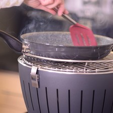 Para preparar el asador Lotus Grill Perdura, sacar el asador de su estuche, y desarmarlo. Voltear la base de cabeza, abrir el compartimento de baterías y colocar las 4 baterías AA en su lugar. Volver a armar el asador. Colocar un poco de alcohol en gel o sólido en la base. Colocar el carbón en la base contenedora de carbón. Encender el alcohol con cuidado y colocar la base con el carbón encima. Colocar la tapa del carbón y por último la parrilla, asegurando los broches. Prender el ventilador girando el botón y esperar 3 a 4 minutos a que el carbón esté encendido. Ajustar el ventilador para obtener la temperatura deseada. Colocar dos una cucharada de aceite sobre el sartén perdura y ponerlo a calentar sobre el asador.