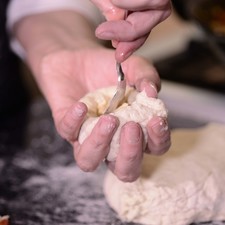 Tomar una bola de masa mediana y humedecer el dedo con un poquito de aceite y hacer un orificio en el centro dando vuelta para que sea como un pozo.