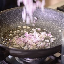 Picar finamente la cebolla, ajo y chiles chipotle. Moler el jitomate guaje cortados en cuartos en la licuadora y reservar. Calentar el sartén Perdura con dos cucharadas de aceite de oliva durante 3 minutos.